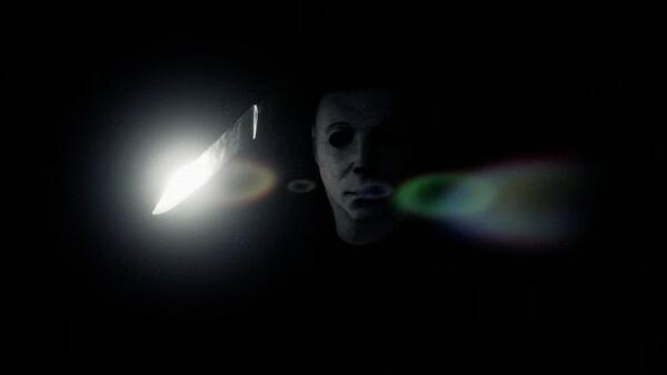Screenshot from Halloween: The Game showing a masked figure holding a knife in a dark setting with eerie lighting.
