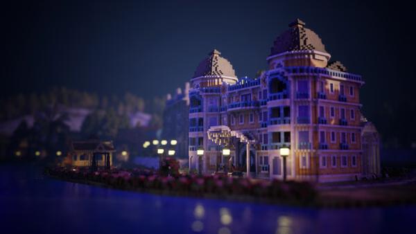 Screenshot from Town to City showing a grand, illuminated riverside mansion at night with a serene water reflection.