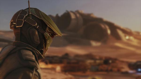 Screenshot from STAR WARS: Galactic Racer™ showing a racer in a green helmet overlooking a desert with wrecked ships in the background.
