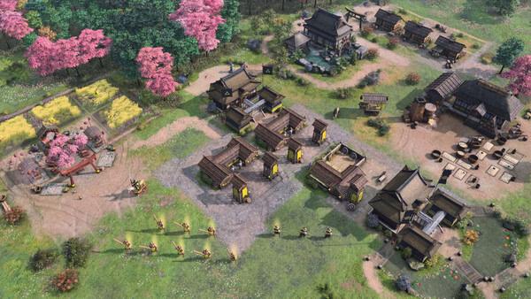 Screenshot from Age of Empires IV: Dynasties of the East showing a vibrant village with buildings, troops, and blooming cherry trees.