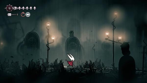 Screenshot from Hollow Knight: Silksong showing the protagonist Hornet walking through a dark, eerie environment with glowing lamps.