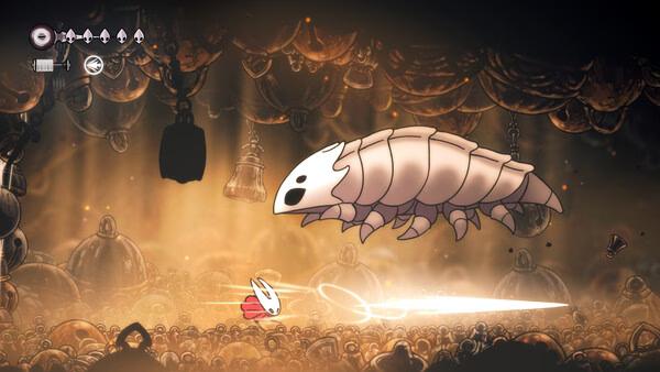 Screenshot of Hollow Knight: Silksong showing a character battling a large, armored insect in a dimly lit cavern.