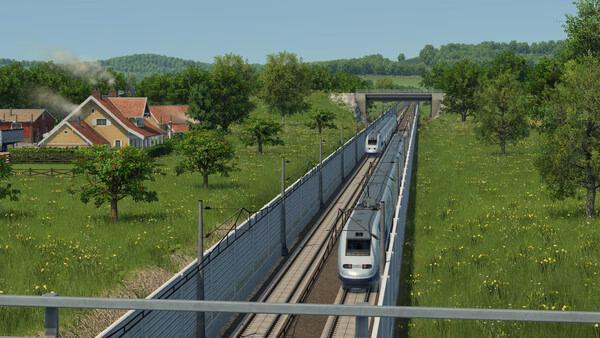 Transport Fever 3 screenshot: A modern train travels on tracks through a green countryside with houses, trees, and a bridge in view.