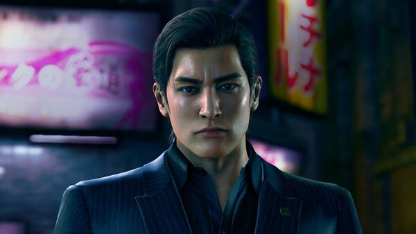 Screenshot from Yakuza Kiwami 3 & Dark Ties showing a man in a suit standing in a city street at night.