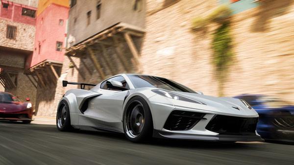 A Forza Horizon 5 screenshot featuring a white sports car speeding through a colorful town, with other cars in the background.