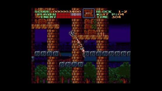 Screenshot from Castlevania Anniversary Collection showing a player attacking with a whip in a castle with brick platforms at night.