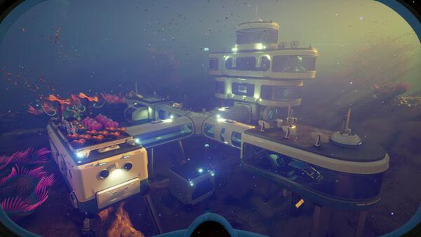 Subnautica 2 screenshot: An underwater base with glowing lights, coral decorations, and vibrant marine plants in a deep ocean environment.