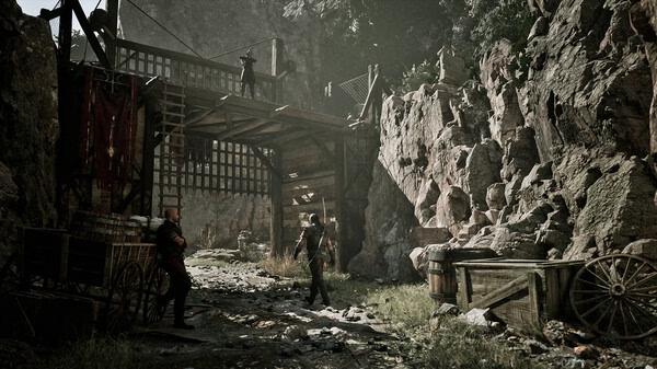 Gothic 1 Remake screenshot: A medieval scene with characters in a mountainous fortress setting, surrounded by wooden carts and rocky cliffs.