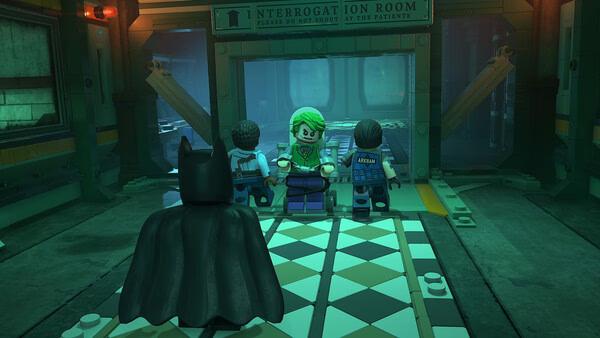 Screenshot from LEGO® Batman™: Legacy of the Dark Knight showing Batman approaching Joker in an interrogation room.