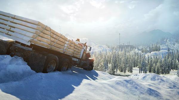 SnowRunner screenshot: A large truck navigates through a snowy landscape with distant mountains and trees under a bright sky.