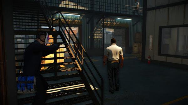 PAYDAY 2 screenshot: A player in a mask crouches by a staircase, observing a guard walking in a dimly lit warehouse environment.