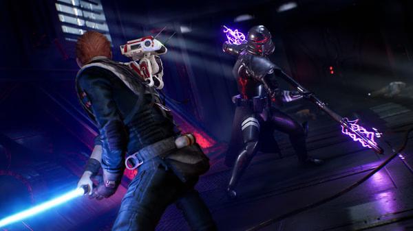 A screenshot from STAR WARS Jedi: Fallen Order showing Cal Kestis battling an enemy wielding an electrified weapon in a dark room.