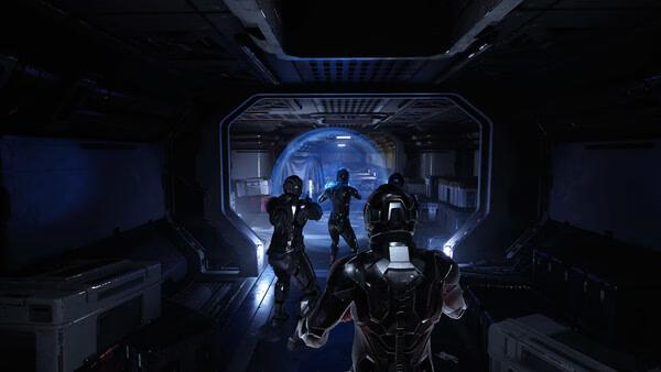 Screenshot from Species: Unknown showing armored characters exploring a dimly lit sci-fi corridor with glowing blue lights.