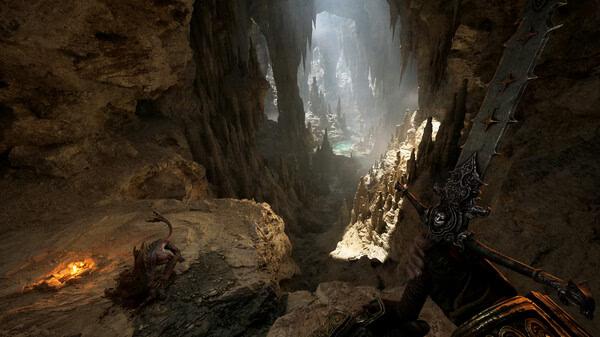 Screenshot from Fatekeeper: A warrior holding a large sword stands at the entrance of a vast, illuminated cavern with stalactites.