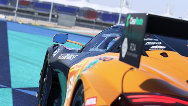 Screenshot from Le Mans Ultimate showing a close-up of a sleek, orange race car on a vibrant blue-green track.