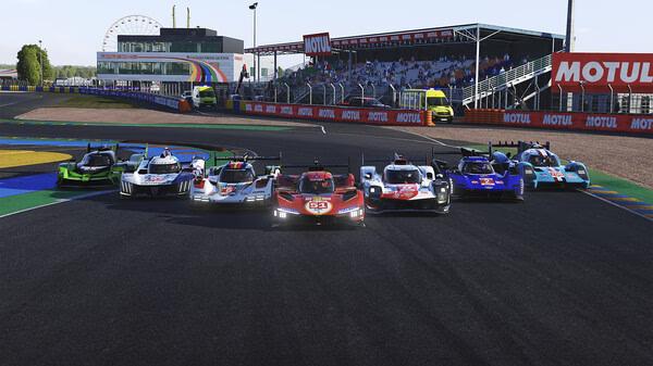 Screenshot from Le Mans Ultimate showing seven race cars lined up on the track with a stadium and Ferris wheel in the background.