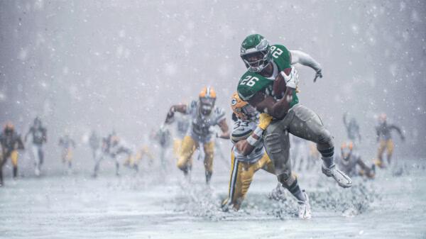 EA SPORTS Madden NFL 26 screenshot featuring a player wearing green (#26) breaking tackles in heavy snow during a football game.