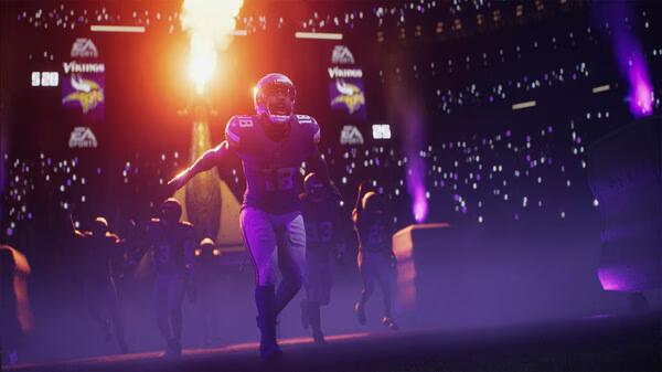 EA SPORTS Madden NFL 26 screenshot: Players in Minnesota Vikings jerseys run onto the field surrounded by stadium lights and smoke.