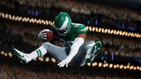 EA SPORTS Madden NFL 26 screenshot: Football player in mid-air, holding the ball, wearing green and white uniform in a stadium.