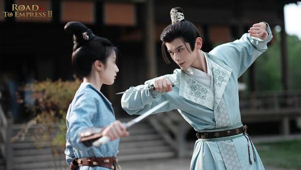 Screenshot from Road to Empress II showing two characters in traditional attire engaged in a sword duel outside a wooden building.
