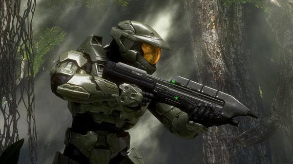 Screenshot from Halo: The Master Chief Collection showing Master Chief in armor, holding a gun in a lush forest setting.