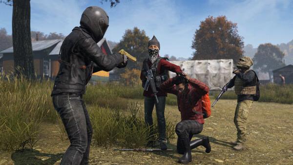 DayZ screenshot: A player in a helmet points a gun at another kneeling player, surrounded by armed characters in a rural setting.