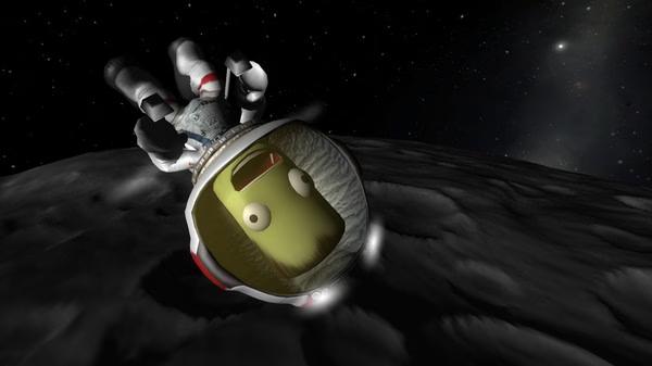 Kerbal Space Program screenshot: A Kerbal astronaut floats in space above a gray, cratered surface with stars visible in the background.