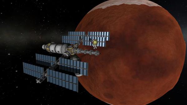 A screenshot from Kerbal Space Program showing a spacecraft with solar panels orbiting a reddish planet in space.