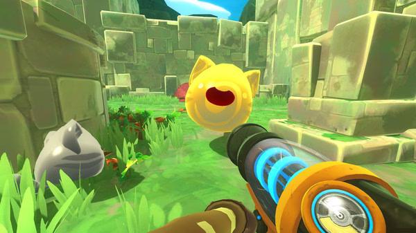 Screenshot from Slime Rancher showing a player aiming a vacuum tool at a yellow slime in a grassy stone ruin environment.