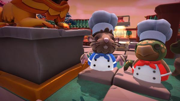 Overcooked! 2 screenshot: Two cartoon chefs stand next to a statue in a vibrant outdoor setting.