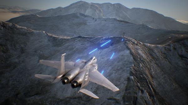 A fighter jet soars over snowy mountains in an ACE COMBAT 7: SKIES UNKNOWN screenshot, with blue tracer rounds visible.