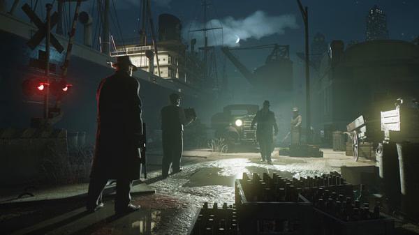 Screenshot from Mafia: Definitive Edition showing characters standing near a dock with crates and a ship under a moonlit sky.