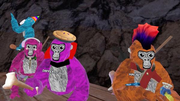 Screenshot from Gorilla Tag showing colorful gorilla avatars wearing party hats and holding items against a rocky backdrop.