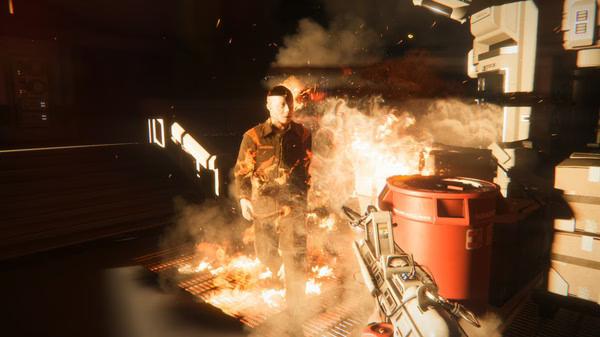 Alien: Isolation screenshot: A man engulfed in flames stands near industrial equipment, while the player's weapon is visible in the foreground.