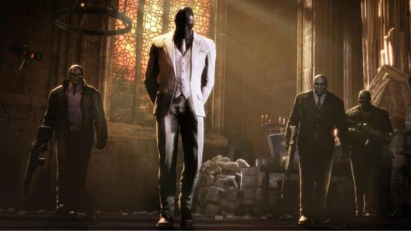 Batman: Arkham Origins screenshot showing Black Mask walking in a cathedral, flanked by armed henchmen under dramatic lighting.