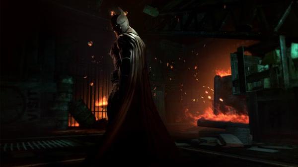 Batman: Arkham Origins screenshot: Batman stands in a dimly lit, fiery room, surrounded by debris and glowing embers.