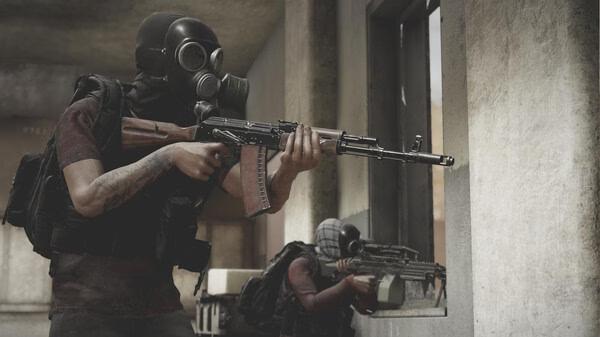 Insurgency: Sandstorm screenshot: Two characters in tactical gear, one aiming a rifle, the other crouching with a weapon indoors.