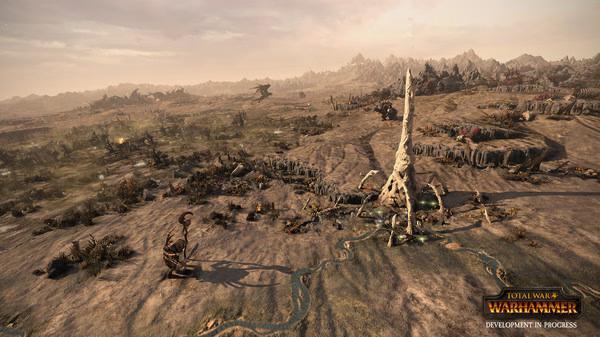 Screenshot from Total War: WARHAMMER showing a desert landscape with a large, spiral structure and scattered armies.