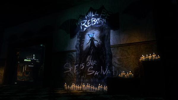 BioShock 2 screenshot: A dimly lit hallway with a mural reading "She Will Be Reborn," surrounded by glowing candles.