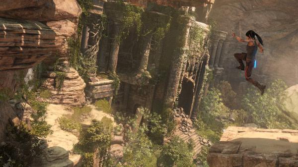 Lara Croft leaps across a canyon toward ancient ruins in a lush, rocky environment in this Rise of the Tomb Raider screenshot.