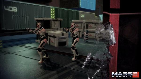 Mass Effect 2 screenshot: Two armored soldiers and a cloaked figure are in a futuristic warehouse with numbered crates.