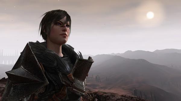 Dragon Age II screenshot: Character in dark armor stands on a rocky cliff overlooking a vast, barren landscape under a hazy sky.