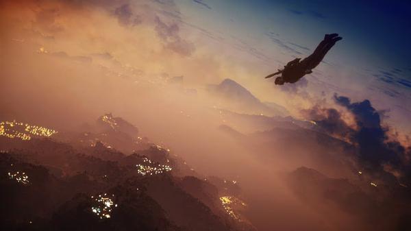 A Just Cause 3 screenshot showing a character skydiving over a vast, mountainous landscape at sunset.