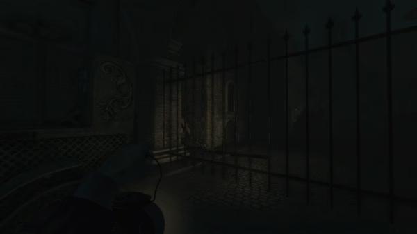 Screenshot from "Amnesia: A Machine for Pigs" showing a dark, eerie alley with a locked gate and faintly visible building details.