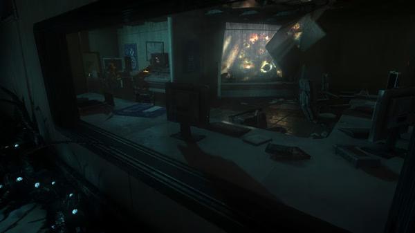 SOMA screenshot: A dark laboratory with computers, glowing machinery, and scattered debris visible through a glass window.