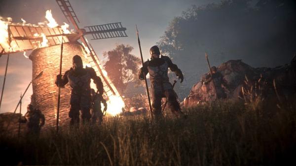 A screenshot from A Plague Tale: Innocence shows armored soldiers with spears near a burning windmill in a grassy field at dusk.