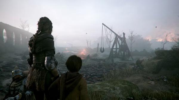 Screenshot from A Plague Tale: Innocence showing characters overlooking a battlefield with a catapult and scattered bodies.