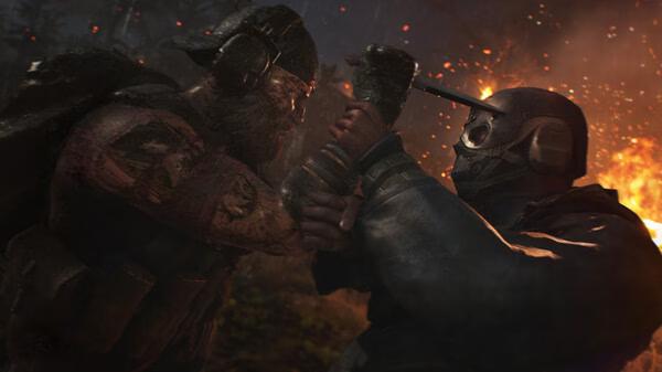 Screenshot from Tom Clancy's Ghost Recon Breakpoint showing two characters in combat, one wielding a knife in a fiery forest setting.