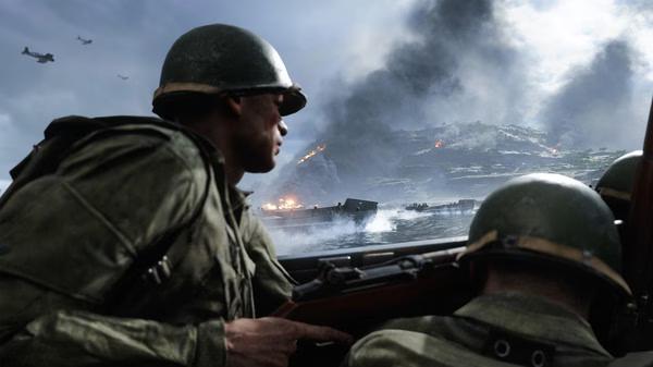 Soldiers in helmets on a boat approach a war-torn beach under heavy smoke in a Battlefield V screenshot.