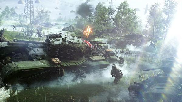 Battlefield V screenshot: A tank navigates through a misty, war-torn landscape with soldiers nearby and parachutes in the sky.